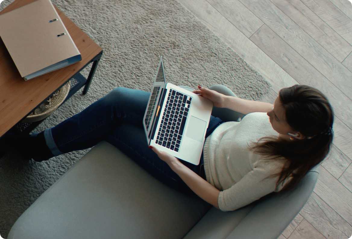 Image of a woman holding a laptop on her lap on Skill Developers' website